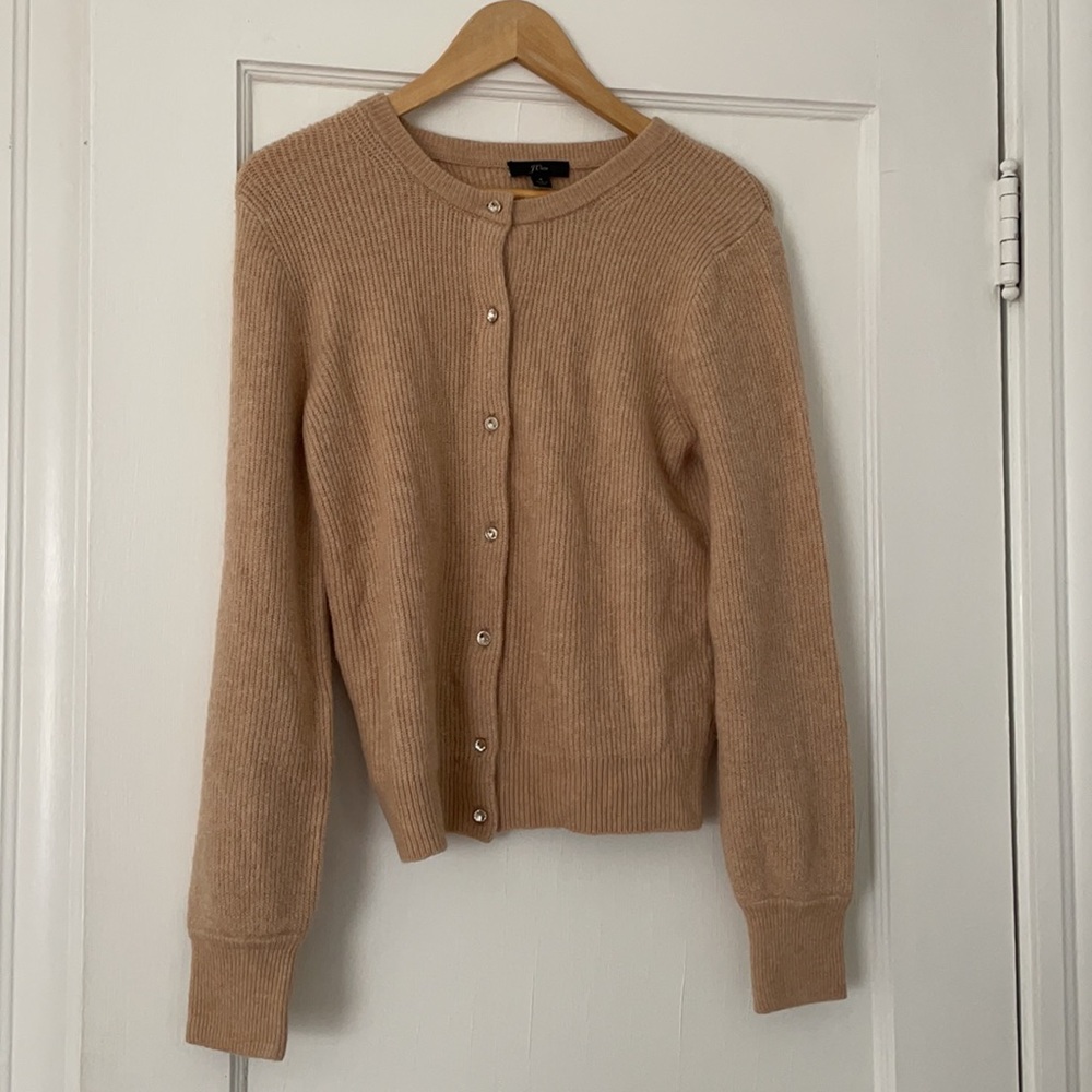 A tan j crew sweater with buttons.
